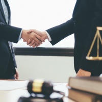 Law and Legal services concept. Lawyer and attorney having team meeting at law firm. Lawyer and businessman handshake.